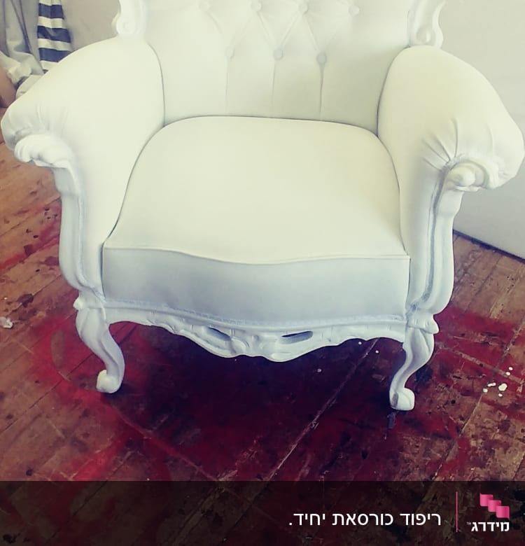 כורסה מרופדת בלבן עם עיטורים דקורטיביים